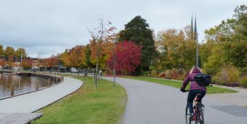 Person biking down road next to river